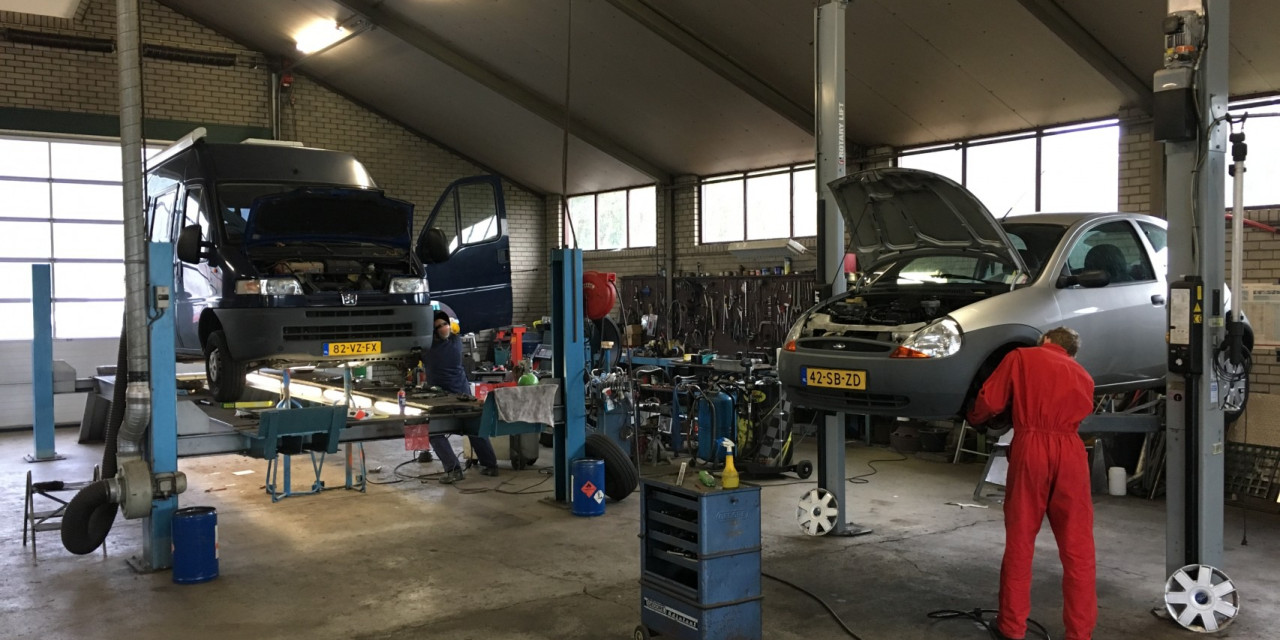 De werkplaats met auto's op de hefbrug